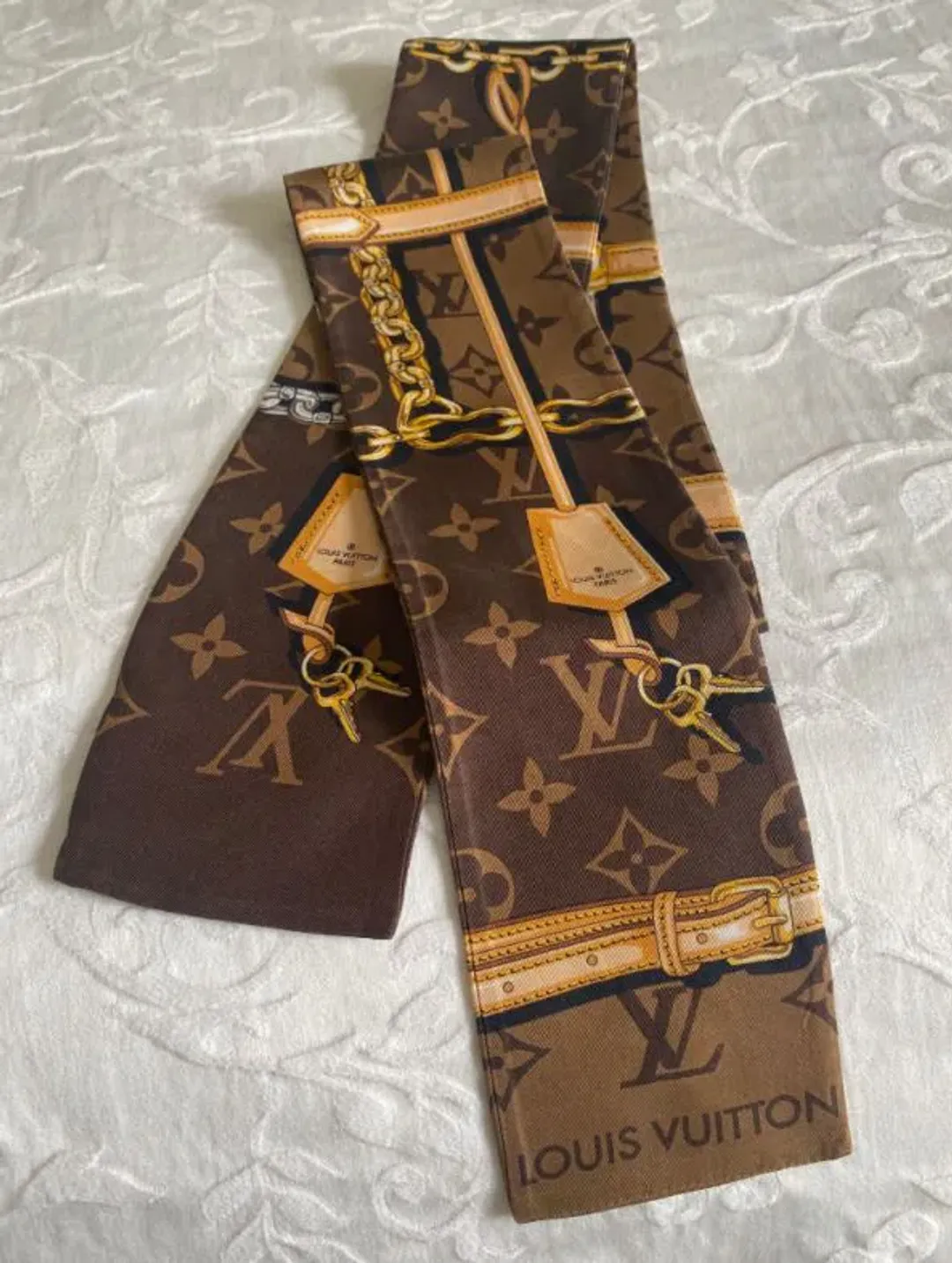 Louis Vuitton Silk Monogram Confidential Bandeau Scarf Brown for rent on The Volte - main image