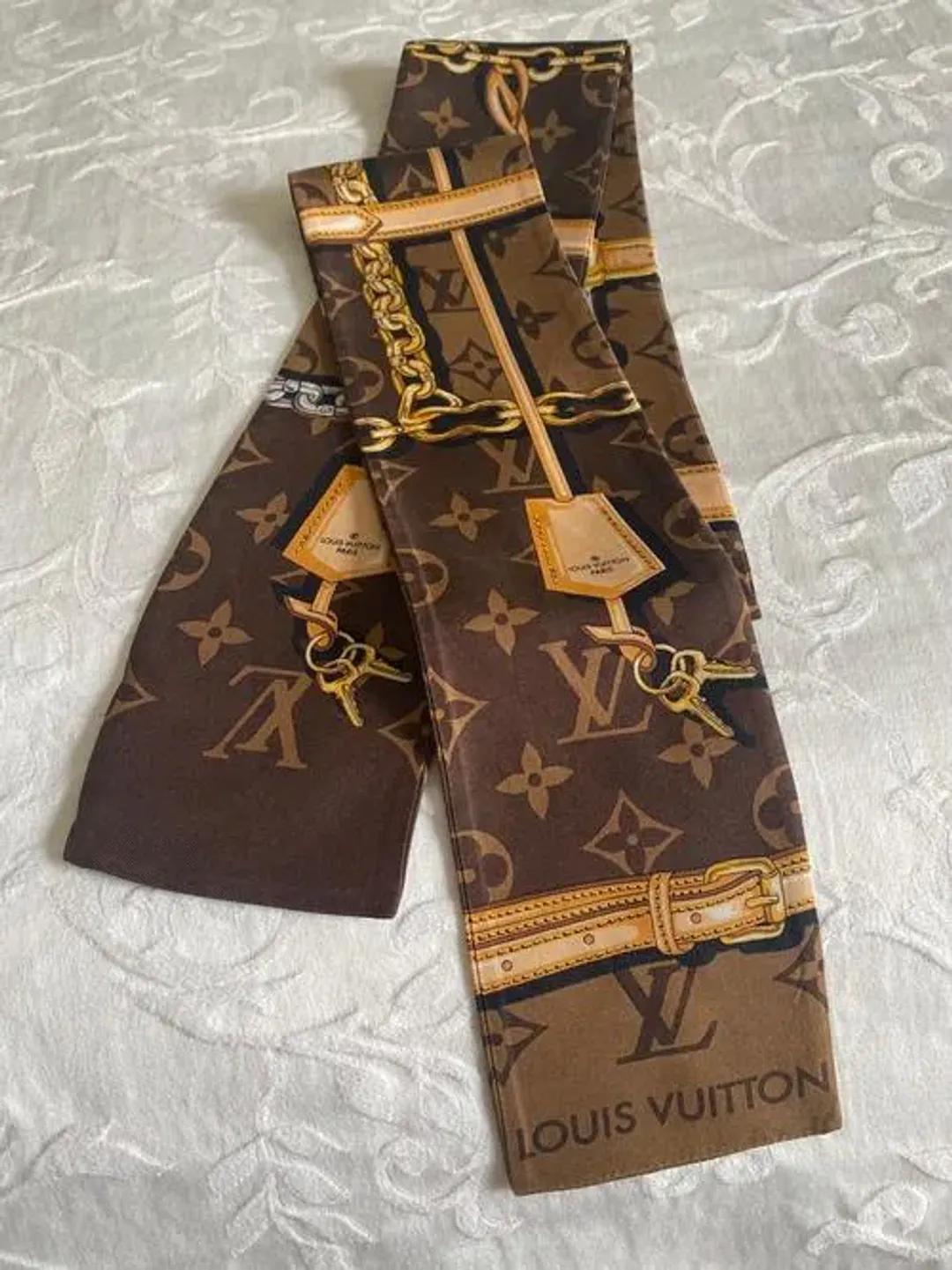 Louis Vuitton Silk Monogram Confidential Bandeau Scarf Brown for rent on The Volte - main image